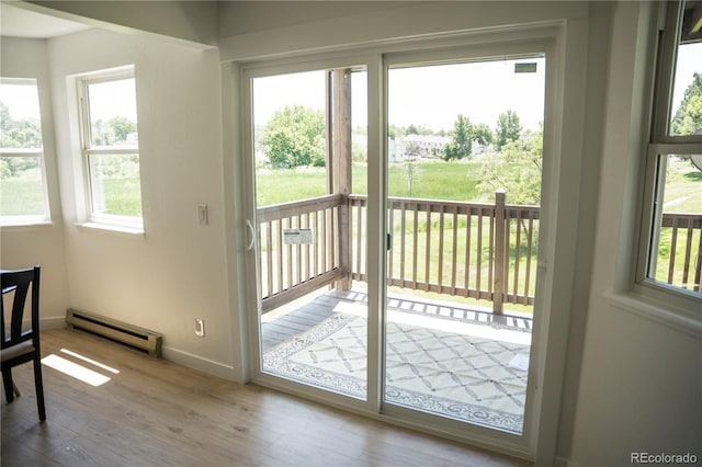 17361 E Mansfield Ave Unit 521R, Aurora, CO 80013 - entryway featuring a baseboard heating unit, wood finished floors, and plenty of natural light