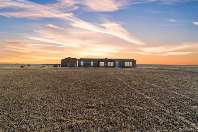 yard at dusk featuring an outdoor structure