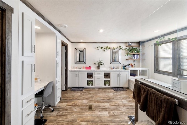 interior space with light wood-type flooring, white cabinets, open shelves, and light countertops