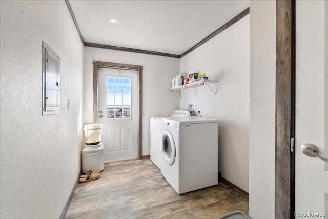 laundry room featuring light wood-style floors, ornamental molding, separate washer and dryer, laundry area, and baseboards