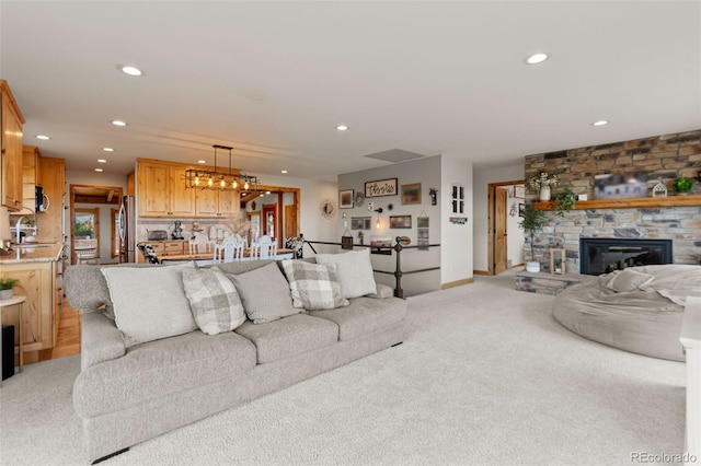 1380 Oak Valley Rd, Sedalia, CO 80135 - living area with light carpet, recessed lighting, a stone fireplace, and a chandelier