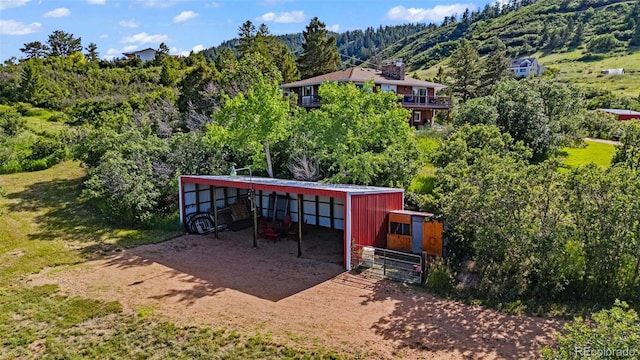 1380 Oak Valley Rd, Sedalia, CO 80135 - view of patio / terrace featuring an outdoor structure, an exterior structure, a wooded view, a detached carport, and dirt driveway
