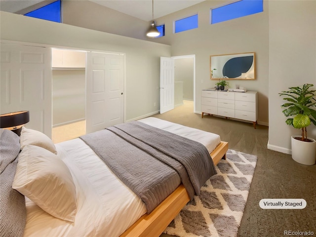 carpeted bedroom with a high ceiling and a closet