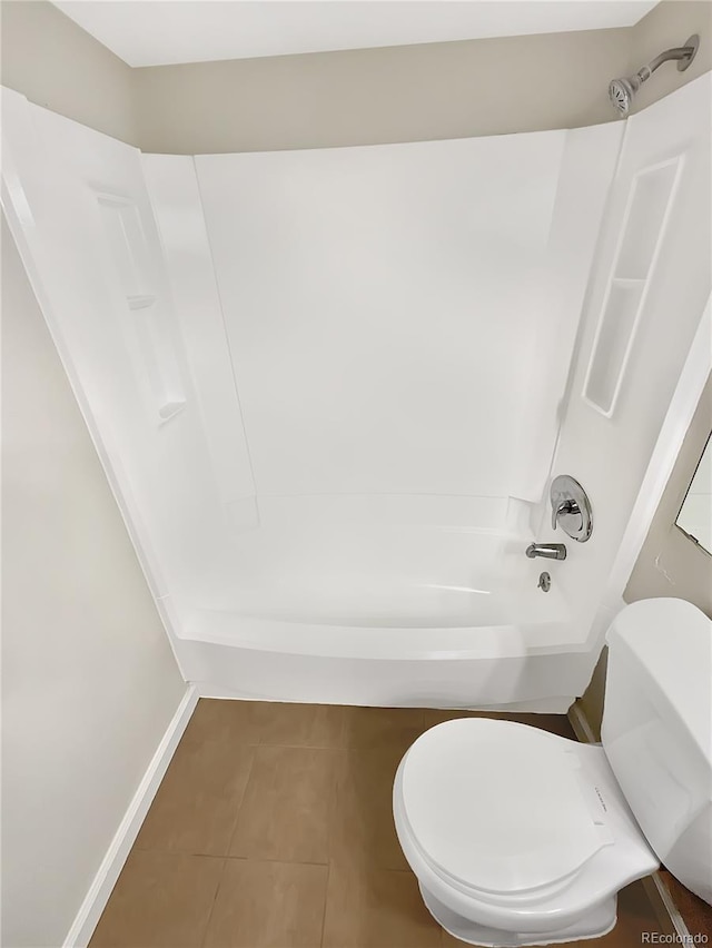 bathroom with tile patterned flooring, bathing tub / shower combination, and toilet