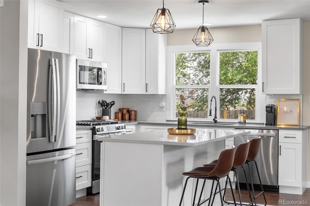 9220 Yucca Way, Thornton, CO 80229 - kitchen with appliances with stainless steel finishes, a sink, a breakfast bar, backsplash, and recessed lighting