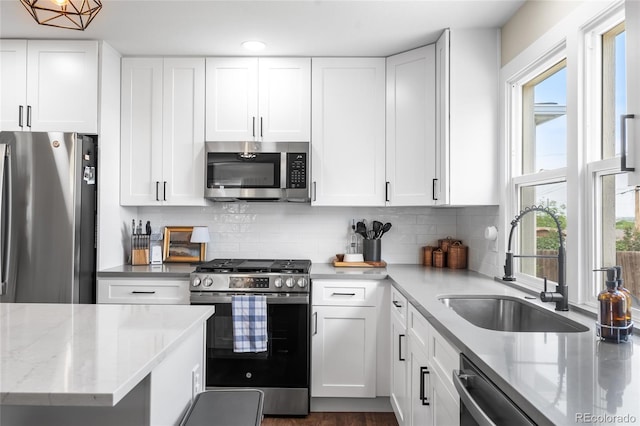 9220 Yucca Way, Thornton, CO 80229 - kitchen with appliances with stainless steel finishes, a sink, plenty of natural light, and white cabinetry