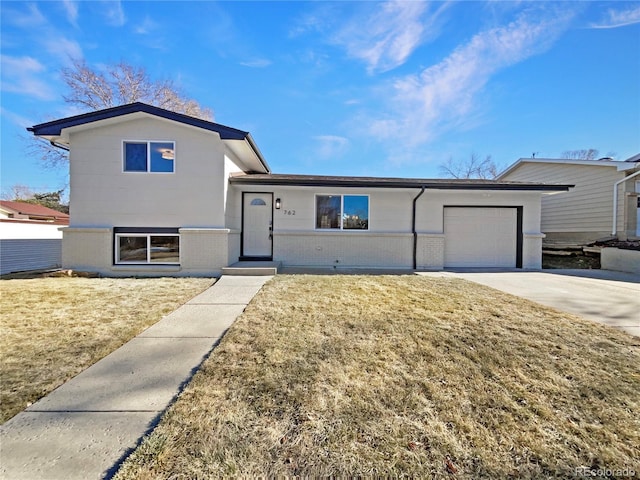 split level home with a front lawn and a garage