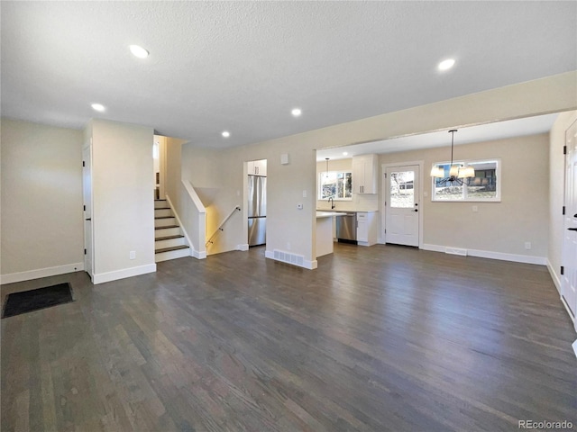 unfurnished living room with dark hardwood / wood-style floors and a textured ceiling