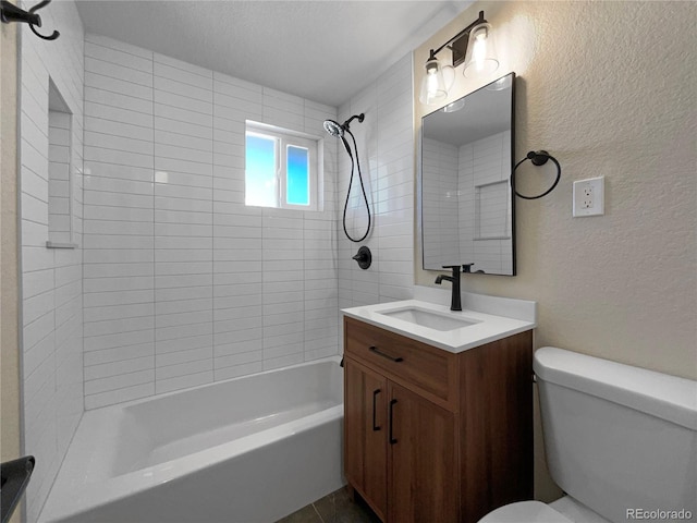 full bathroom with vanity, tiled shower / bath combo, and toilet