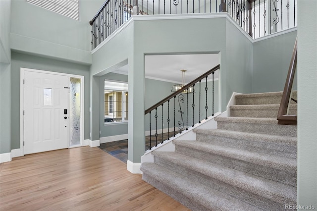 7837 Aravon Ct, Lone Tree, CO 80124 - entryway featuring stairs, a high ceiling, wood finished floors, baseboards, and ornamental molding