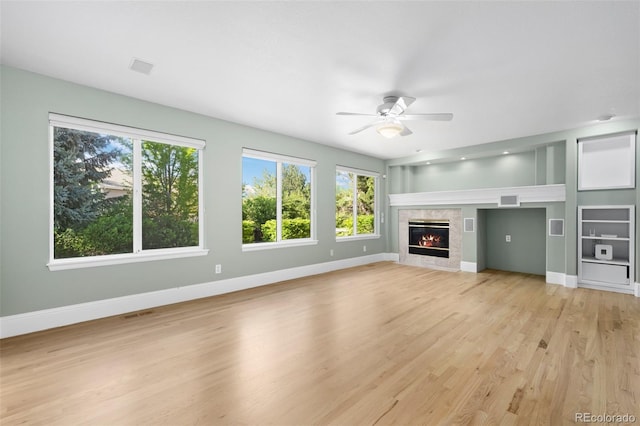 7837 Aravon Ct, Lone Tree, CO 80124 - unfurnished living room with baseboards, a ceiling fan, light wood finished floors, and a fireplace