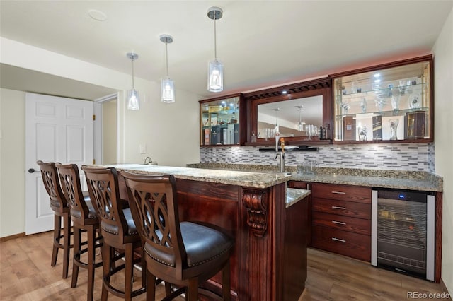 7837 Aravon Ct, Lone Tree, CO 80124 - indoor wet bar featuring beverage cooler, wood finished floors, tasteful backsplash, and pendant lighting