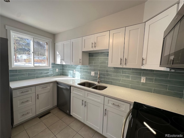 kitchen featuring stainless steel appliances, tasteful backsplash, sink, and white cabinets