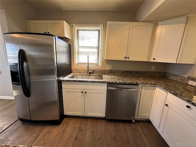 2946 W Park Pl, Denver, CO 80219 - kitchen featuring appliances with stainless steel finishes, dark wood-style floors, white cabinetry, and dark stone countertops