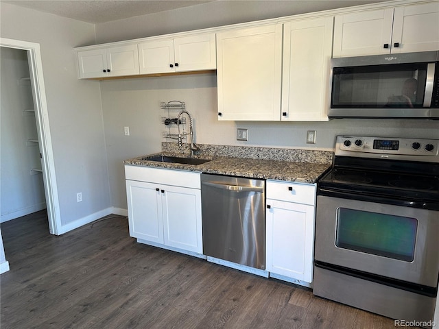 2946 W Park Pl, Denver, CO 80219 - kitchen featuring stainless steel appliances, dark wood-style floors, white cabinets, and dark stone counters