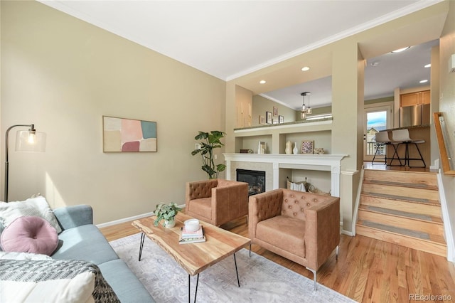 3712 Wolff St, Denver, CO 80212 - living area featuring crown molding, baseboards, light wood-style floors, a glass covered fireplace, and recessed lighting