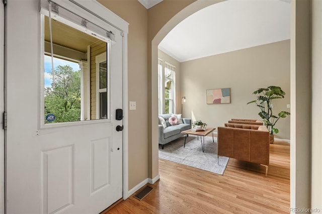 3712 Wolff St, Denver, CO 80212 - foyer featuring arched walkways, healthy amount of natural light, light wood finished floors, crown molding, and baseboards