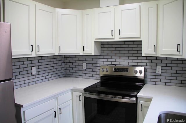 kitchen with backsplash, white cabinets, and appliances with stainless steel finishes