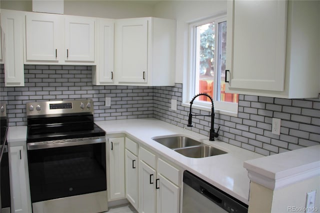 kitchen featuring white cabinets, appliances with stainless steel finishes, backsplash, and sink