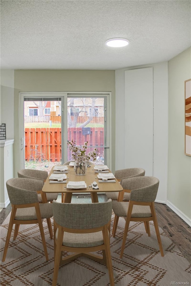 dining room with hardwood / wood-style flooring and a textured ceiling