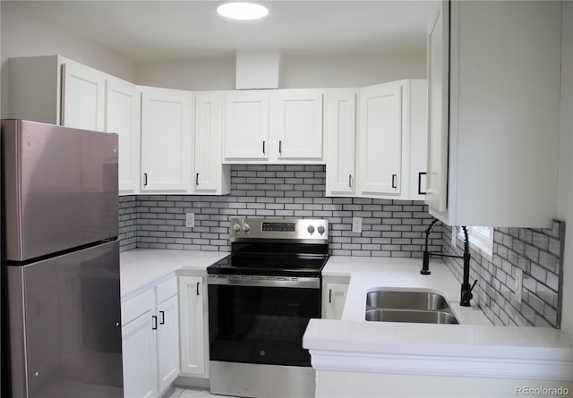 kitchen with backsplash, sink, white cabinets, and appliances with stainless steel finishes