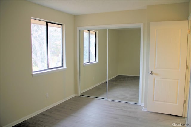 unfurnished bedroom featuring light hardwood / wood-style flooring and a closet