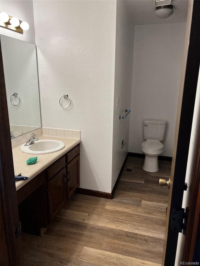 bathroom with vanity, hardwood / wood-style floors, and toilet