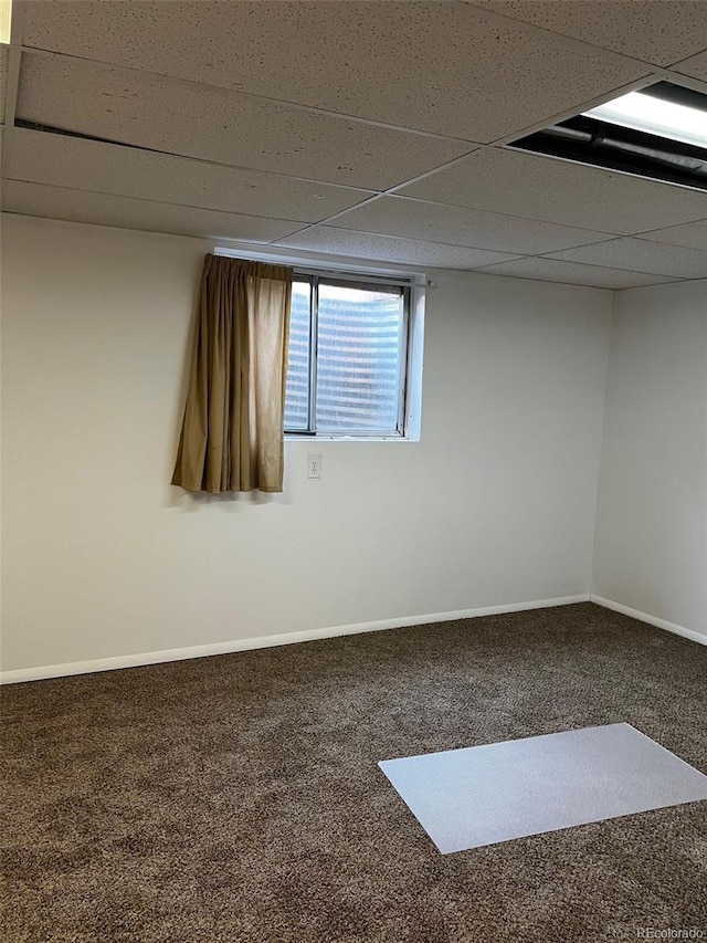 unfurnished room with carpet flooring and a drop ceiling