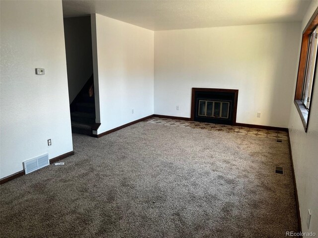 unfurnished living room with dark carpet