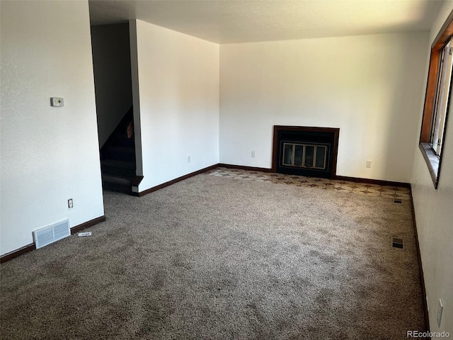 unfurnished living room featuring dark carpet