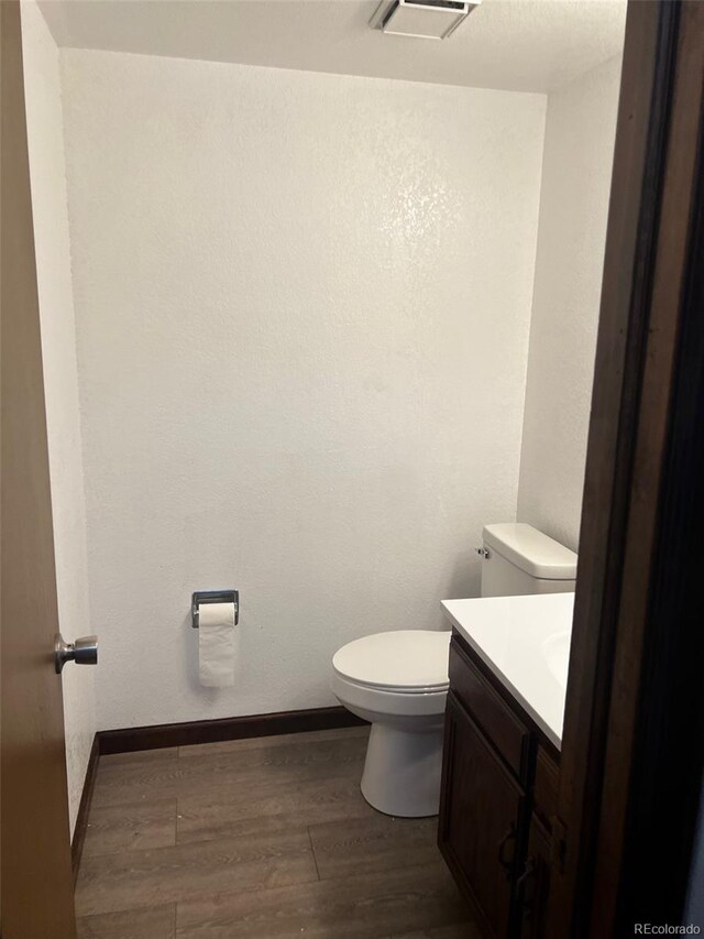 bathroom featuring hardwood / wood-style floors, vanity, and toilet