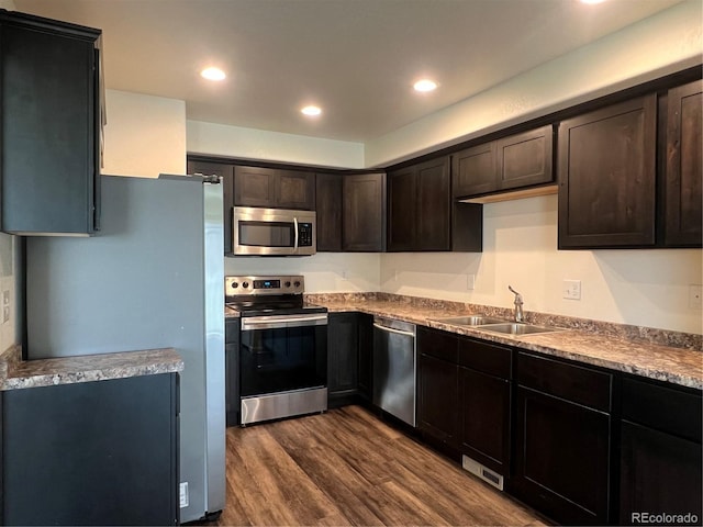 522 Foxtail Pl, Wiggins, CO 80654 - kitchen featuring stainless steel appliances, a sink, dark wood-type flooring, dark brown cabinets, and recessed lighting