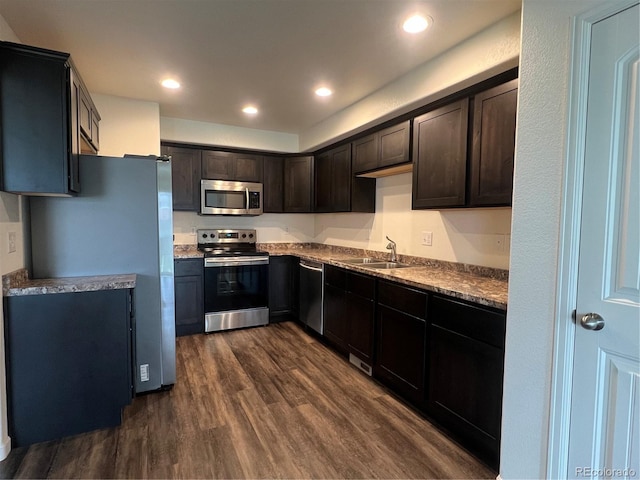 522 Foxtail Pl, Wiggins, CO 80654 - kitchen with stainless steel appliances, dark wood-style floors, a sink, dark brown cabinets, and recessed lighting