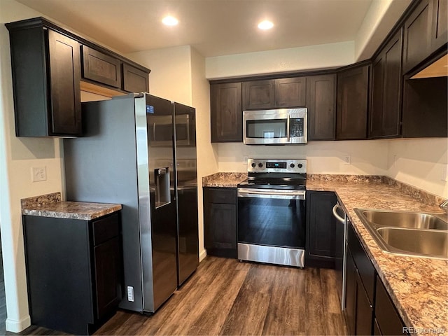 522 Foxtail Pl, Wiggins, CO 80654 - kitchen with appliances with stainless steel finishes, a sink, dark wood-style floors, dark brown cabinets, and recessed lighting