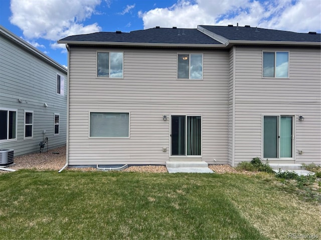 522 Foxtail Pl, Wiggins, CO 80654 - rear view of house with entry steps, a lawn, and central AC unit