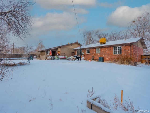 snow covered property with central air condition unit