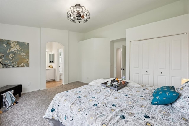 4530 Star Ridge Dr, Colorado Springs, CO 80916 - carpeted bedroom featuring arched walkways, a closet, baseboards, and ensuite bath