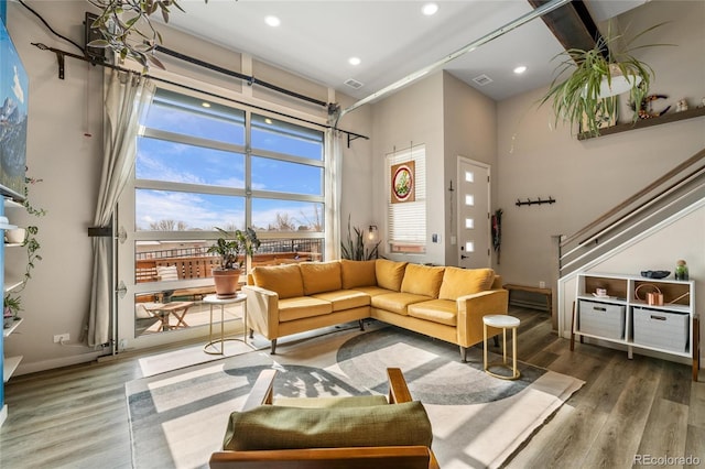 living room with a towering ceiling and hardwood / wood-style floors