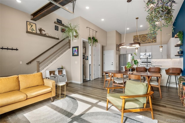 living room with a high ceiling and dark hardwood / wood-style flooring