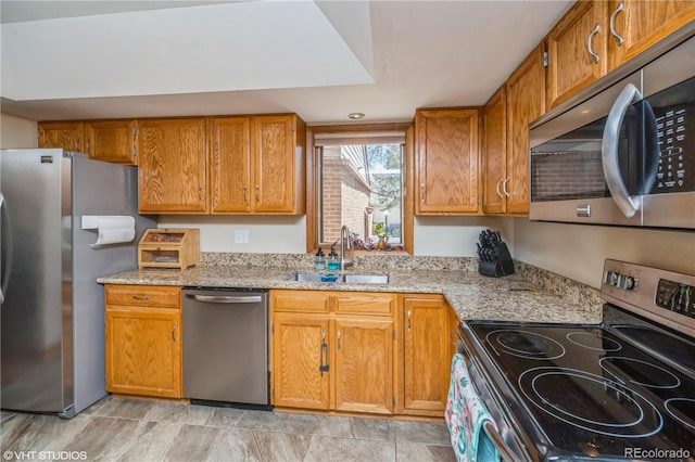 155 Xenon St Unit 33, Lakewood, CO 80228 - kitchen featuring stainless steel appliances, a sink, brown cabinets, and light stone countertops