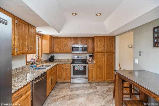 155 Xenon St Unit 33, Lakewood, CO 80228 - kitchen with stainless steel appliances, a sink, a raised ceiling, brown cabinetry, and recessed lighting