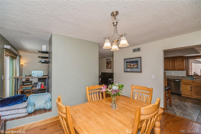 155 Xenon St Unit 33, Lakewood, CO 80228 - dining room with a chandelier, dark wood-style flooring, and a textured ceiling