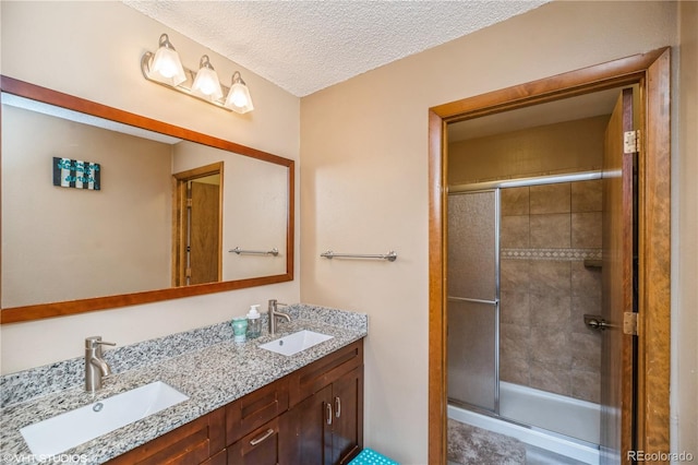 155 Xenon St Unit 33, Lakewood, CO 80228 - full bath featuring a shower stall, a textured ceiling, and double vanity