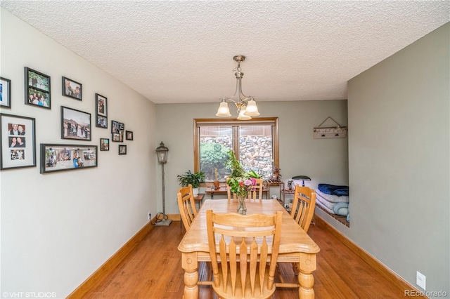 155 Xenon St Unit 33, Lakewood, CO 80228 - dining space with a chandelier, light wood-style floors, a textured ceiling, and baseboards
