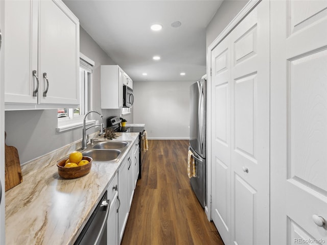 kitchen featuring appliances with stainless steel finishes, a sink, dark wood finished floors, white cabinetry, and recessed lighting