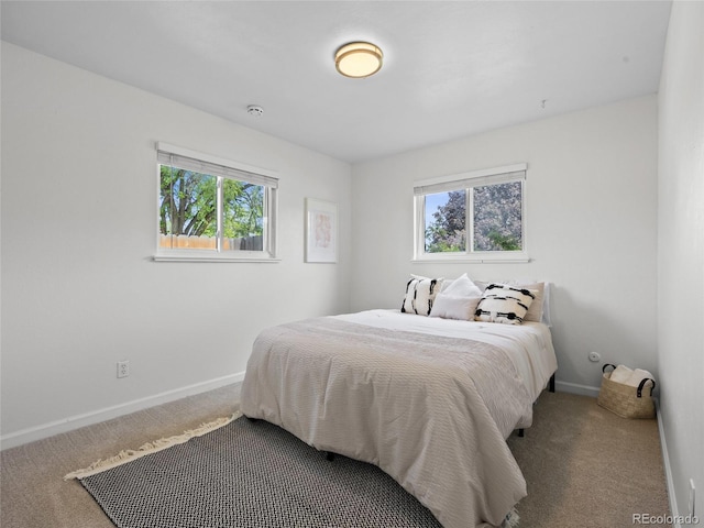 bedroom with carpet floors, multiple windows, and baseboards