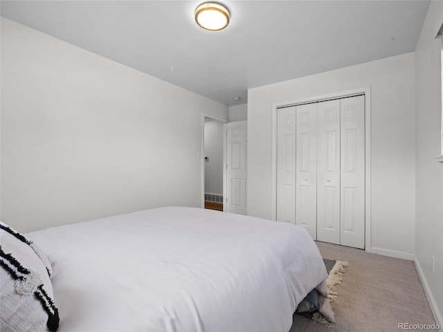 bedroom featuring light colored carpet, baseboards, and a closet