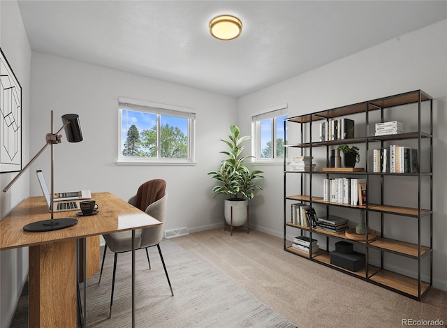 carpeted home office featuring baseboards