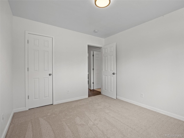 unfurnished bedroom featuring carpet flooring and baseboards