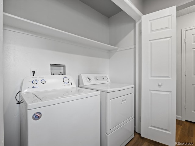 clothes washing area featuring washing machine and dryer and dark wood finished floors